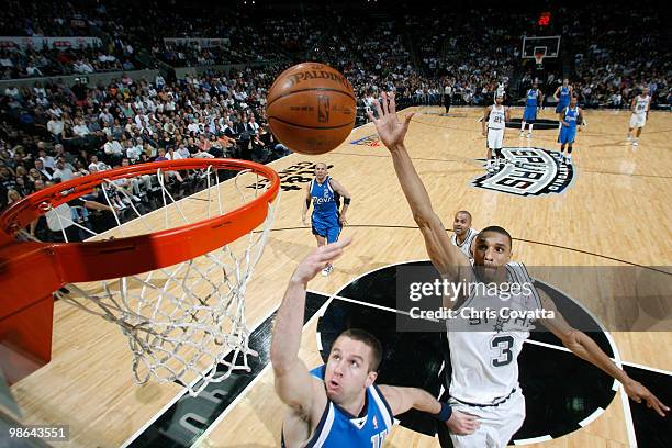 George Hill of the San Antonio Spurs shoots over Jose Juan Barea of the Dallas Mavericks in Game Three of the Western Conference Quarterfinals during...