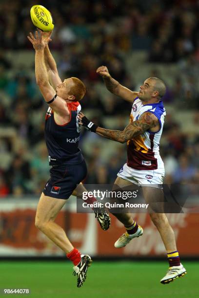 Matthew Bate of the Demons marks infront of Ashley McGrath of the Lions during the round five AFL match between the Melbourne Demons and the Brisbane...