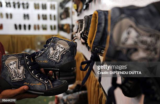 An Indian shopkeeper displays shoes with a caricature of Osama Bin Laden at a shop in Allahabad on April 24, 2010. The Chinese-made shoes which bears...