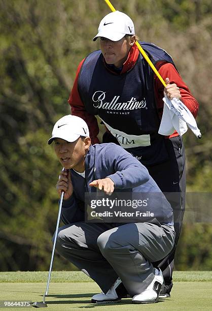 Anthony Kim of USA and his caddie Blodie Flanders line up a putt on the 14th green during the Round Two of the Ballantine's Championship at Pinx Golf...