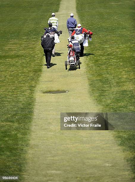 Lam Chih-bing of Singapore, Pablo Larrazabal of Spain, Anthony Kim of USA and their caddies walk on the 13th hole during the Round Two of the...