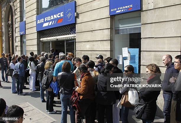 People queue up outside the Air France ticket sales office after the cancellation of their flights on April 19 in Paris. France plans to keep all...