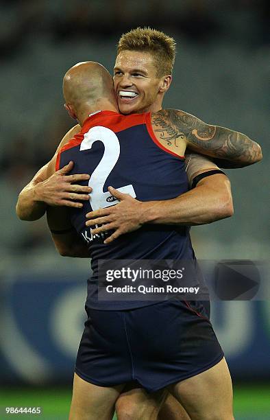 Nathan Jones and Colin Sylvia of the Demons celebrate a goal during the round five AFL match between the Melbourne Demons and the Brisbane Lions at...