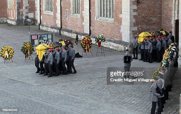 The guards of honor carry the coffins after a funeral service for four killed German ISAF soldiers at the catherdal on April 24, 2010 in Ingolstadt,...