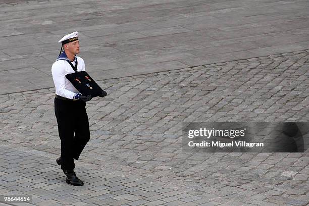 Navy soldier carries the medals of a dead soldier after a funeral service for four killed German ISAF soldiers at the catherdal on April 24, 2010 in...