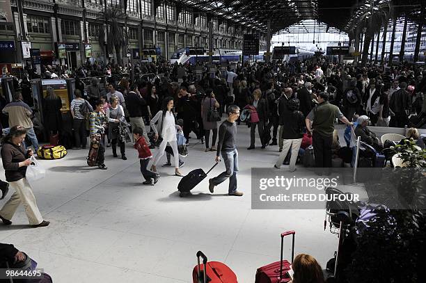 Travellers wait on April 18 at the Gare de Lyon railway station in Paris, to take trains to the South as main French airports remained closed due to...