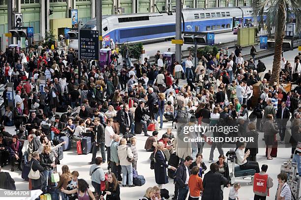 Travellers wait on April 18 at the Gare de Lyon railway station in Paris, to take trains to the South as main French airports remained closed due to...