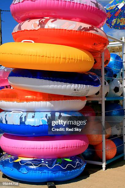 rubber rings and footballs for sale by the beach - newpremiumuk stock pictures, royalty-free photos & images