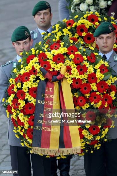 Soldiers carry a wreath with the writing 'The Chancellor of the Federal Republic of Germany' during a funeral service for four killed German ISAF...
