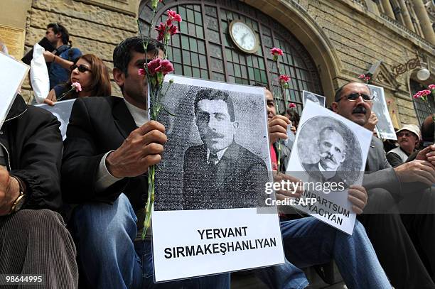 Human rights activists hold pictures of Armenian victims in front of the historical Haydarpasa station at Kadikoy in Istanbul on April 24 during a...