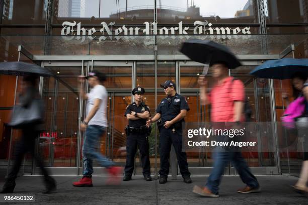 Members of the New York City Police Department stand outside the headquarters of The New York Times, June 28, 2018 in New York City. NYPD announced...