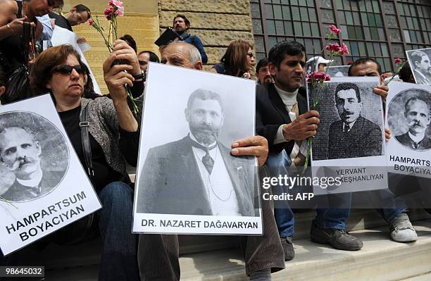 Human rights activists hold pictures of Armenian victims in front of the historical Haydarpasa station at Kadikoy in Istanbul on April 24 during a...