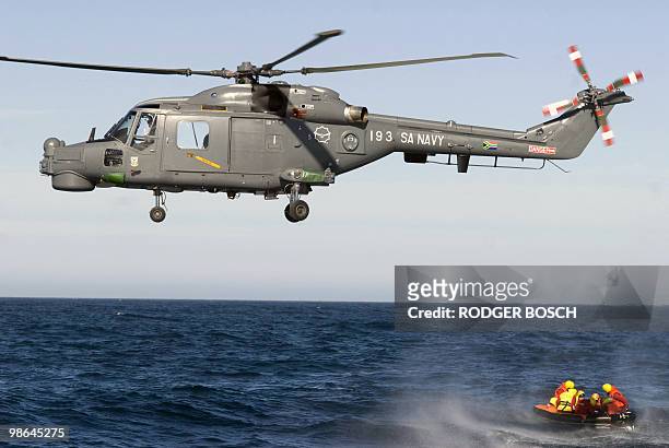An SA Navy Westland Lynx plane flies above a life raft during an exercise as the National Sea Rescue Institute , and the South Africa Air Force,...