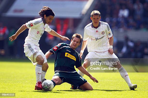 Danijel Pranjic and Bastian Schweinsteiger of Muenchen challenge Thorben Marx of Moenchengladbach during the Bundesliga match between Borussia...