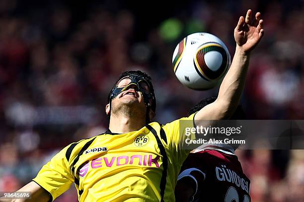 Nuri Sahin of Dortmund jumps for a header with Ilkay Guendogan of Nuernberg during the Bundesliga match between 1. FC Nuernberg and Borussia Dortmund...