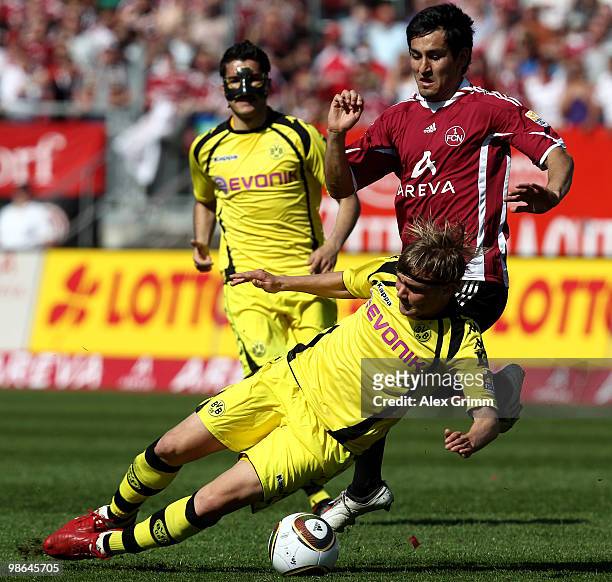 Ilkay Guendogan of Nuernberg is challenged by Marcel Schmelzer of Dortmund during the Bundesliga match between 1. FC Nuernberg and Borussia Dortmund...