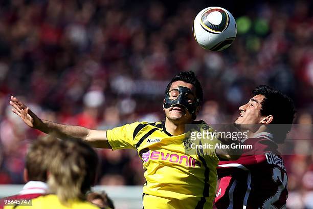 Nuri Sahin of Dortmund jumps for a header with Ilkay Guendogan of Nuernberg during the Bundesliga match between 1. FC Nuernberg and Borussia Dortmund...
