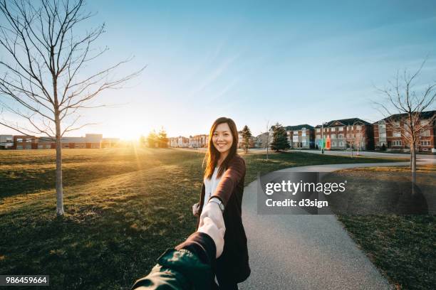 beautiful couple in love holding hands and relaxing in park at sunset - walking personal perspective stock pictures, royalty-free photos & images