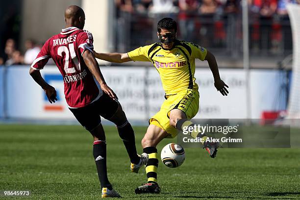 Nuri Sahin of Dortmund is challenged by Mickael Tavares of Nuernberg during the Bundesliga match between 1. FC Nuernberg and Borussia Dortmund at the...