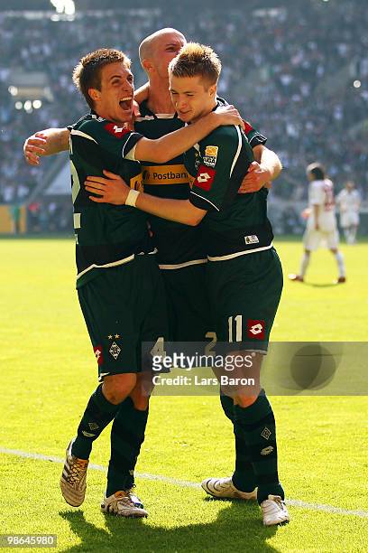 Marco Reus of Moenchengladbach celebrates scoring the first goal with team mates Thorben MArx and Michael Bradley during the Bundesliga match between...