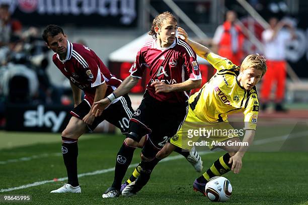 Jakub Blaszczykowski of Dortmund is challenged by Javier Pinola and Albert Bunjaku of Nuernberg during the Bundesliga match between 1. FC Nuernberg...