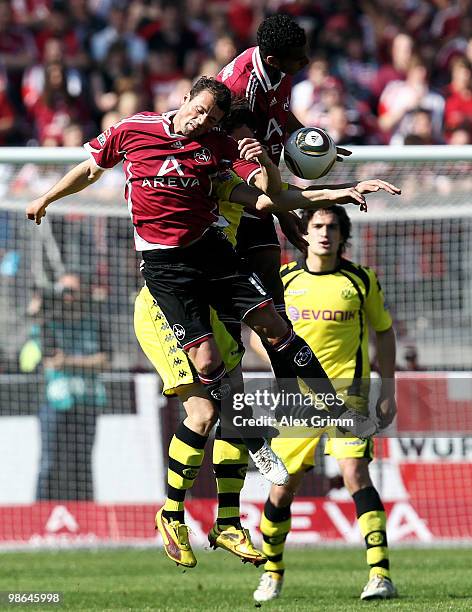 Nuri Sahin of Dortmund jumps for a header with Albert Bunjaku and Maxim Choupo-Moting of Nuernberg during the Bundesliga match between 1. FC...