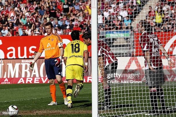 Lucas Barrios of Dortmund scores his team's third goal as Raphael Schaefer, Dominic Maroh and Javier Pinola of Nuernberg react during the Bundesliga...
