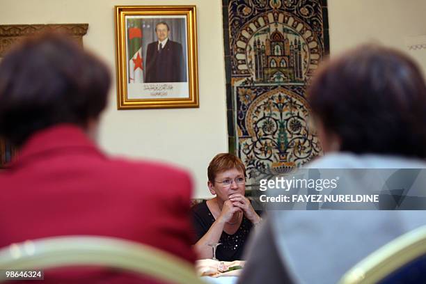 Secretary General of the French Communist party Marie-George Buffet sits under the picture of Algerian President Abdelazziz Bouteflika during a...