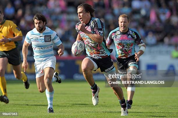 Stade Francais's fullback Hugo Bonneval powers his way to score a try despite Metro Racing's scrum-half Jerome Fillol during their French Top 14...