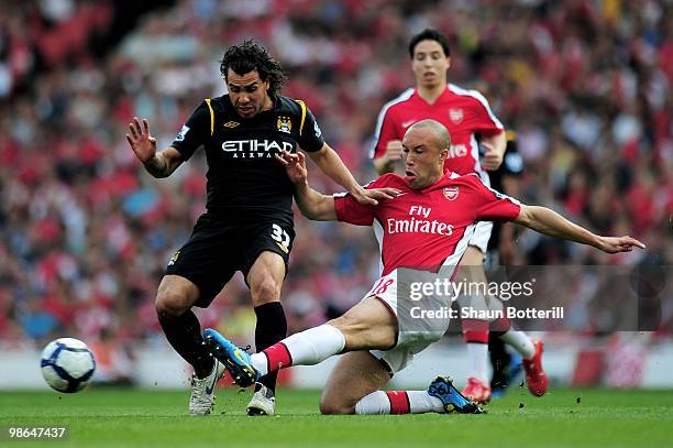 Carlos Tevez of Manchester City is tackled by Mikael Silvestre of Arsenal during the Barclays Premier League match between Arsenal and Manchester...