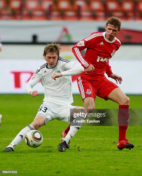 Dmitri Tarasov of FC Lokomotiv Moscow battles for the ball with Aleksandr Kharitonov of FC Tom Tomsk during the Russian Football League Championship...