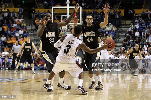 Dee Bost of the Mississippi State Bulldogs looks to pass the ball as he is defended by Steve Tchiengang and Jeffery Taylor of the Vanderbilt...