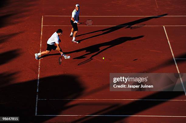 Mark Knowles of the Bahamas plays a backhand flanked by his doubles partner Lleyton Hewitt of Australia during the semi final match agsinst Mariusz...