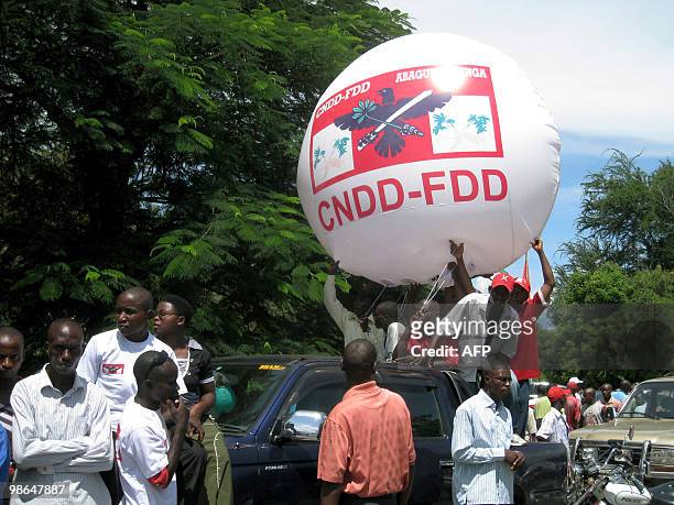 Sympathizers of the council of the Defense of the Democracy-Democratic Defense Forces political party, carry a giant inflatable ball adorned with the...