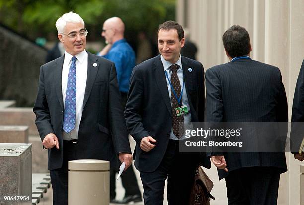 Alistair Darling, U.K. Chancellor of the exchequer, left, walks between buildings during the IMF-World Bank spring meetings in Washington, D.C.,...