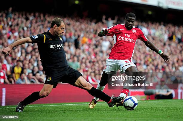 Emmanuel Eboue of Arsenal is tackled by Pablo Zabaleta of Manchester City during the Barclays Premier League match between Arsenal and Manchester...