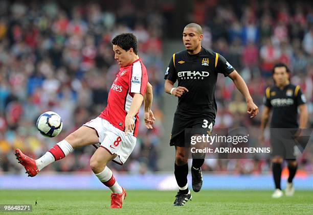 Arsenal's French midfielder Samir Nasri plays a pass while Manchester City's Dutch player Nigel De Jong chases him down during the Premiership match...