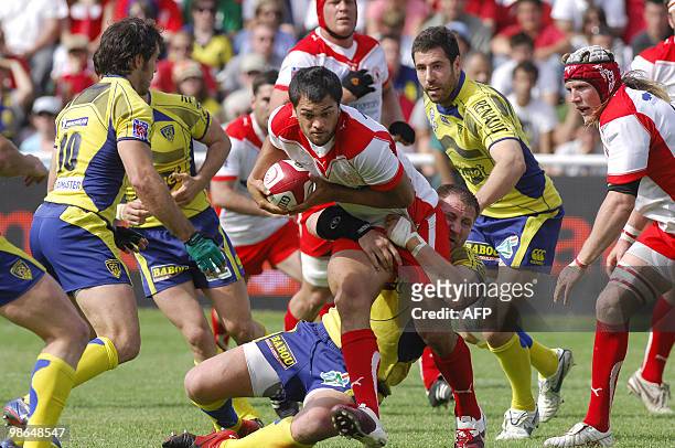 Biarritz' Australian centre Karmichael Hunt is tackled by Clermont's Elvis Vermeulen as Clermont's French center Julien Malzieu looks on during the...
