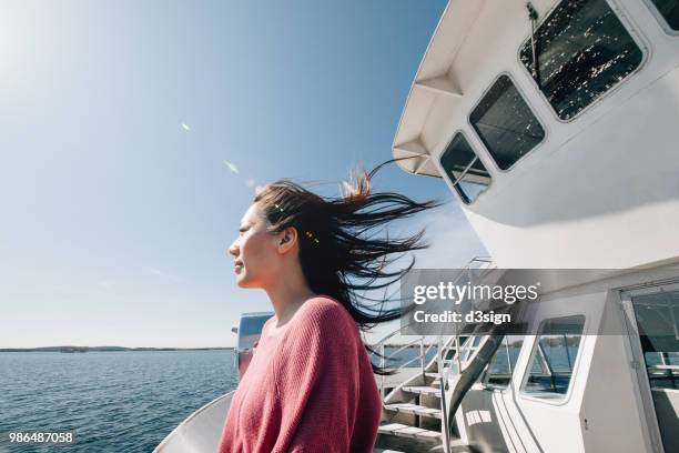 young woman traveller enjoying the sea and breeze from cruise ship - cruise deck stock-fotos und bilder