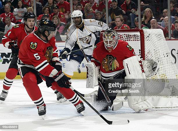 Goalie Antti Niemi of the Chicago Blackhawks watches for the puck as teammates Brent Sopel and Niklas Hjalmarsson watch with Joel Ward of the...