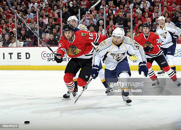 Andrew Ladd of the Chicago Blackhawks and Francis Bouillon of the Nashville Predators chase after the puck as Dave Bolland of the Blackhawks watches...