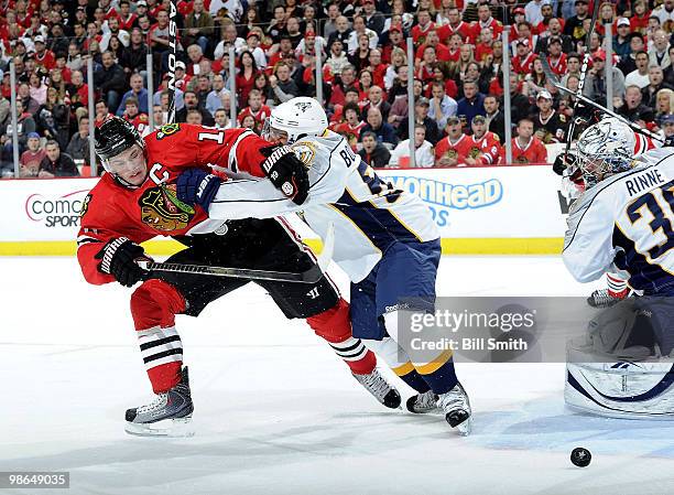 Jonathan Toews of the Chicago Blackhawks watches the puck as Francis Bouillon of the Nashville Predators pushes into him, in front of Nashville...