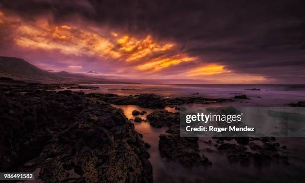 fire in a storm sky - playa de las americas stock pictures, royalty-free photos & images