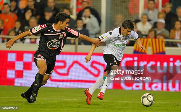 Valencia's forward David Villa vies for the ball with Deportivo's Rochella during their Spanish league football match at Mestalla stadium on April...