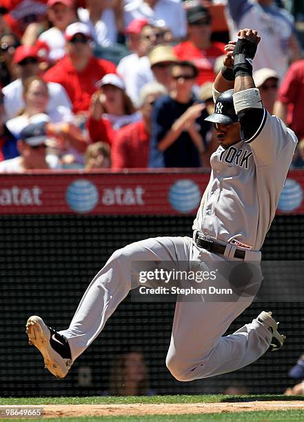 Robinson Cano of the New York Yankees slides into home to score on a Francisco Cervelli single in the fourth inning against the Los Angeles Angels of...
