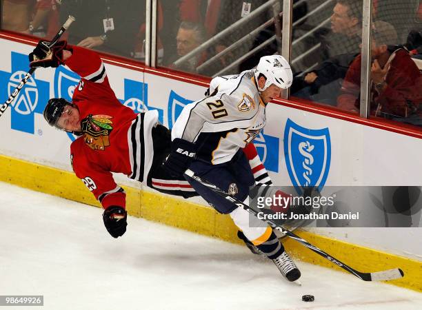 Bryan Bickell of the Chicago Blackhawks falls to the ice as battles for the puck with Ryan Suter of the Nashville Predators in Game Five of the...