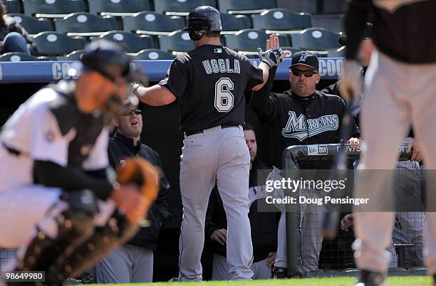 Dan Uggla of the Florida Marlins is welcomed back to the dugout by manager Fredi Gonzalez after his second inning solo homerun against the Colorado...