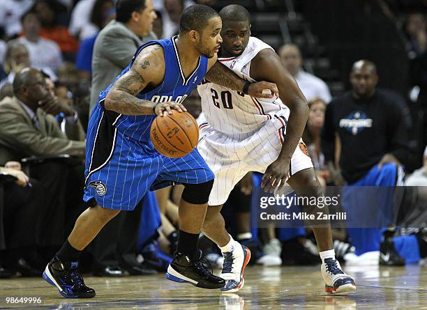 Guard Jameer Nelson of the Orlando Magic dribbles witht the ball while guard Raymond Felton of the Charlotte Bobcats defends him during Game Three of...