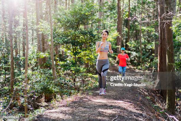 fitness female trail runners running on a mountain path - cross country road trip stock pictures, royalty-free photos & images