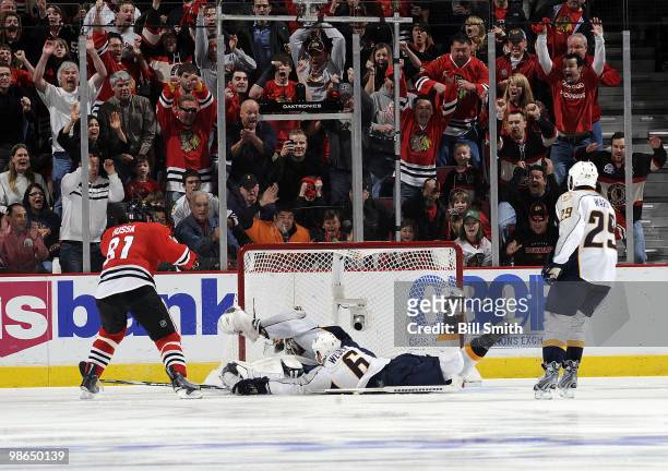 Marian Hossa of the Chicago Blackhawks slips the puck past Nashville Predators goalie Pekka Rinne to win the game in overtime at Game Five of the...
